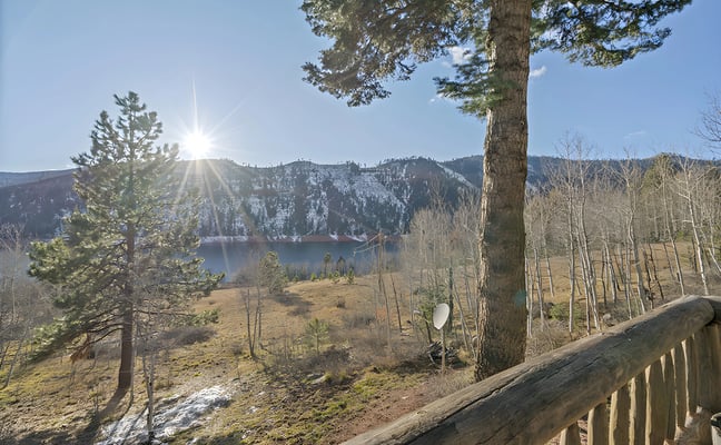 Lake and mountain view through aspens from a cabin deck