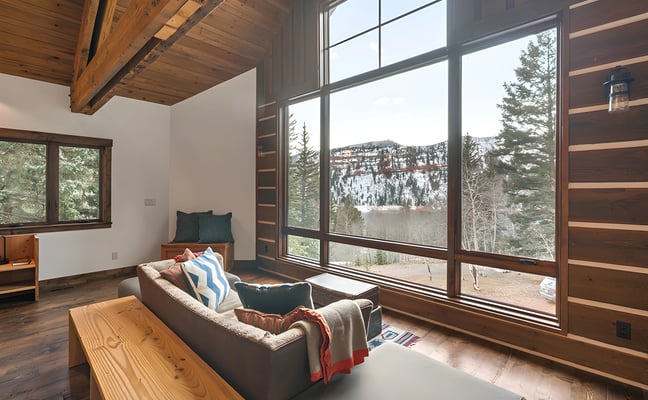 Log cabin exterior with snow, fire pit, and mountain views