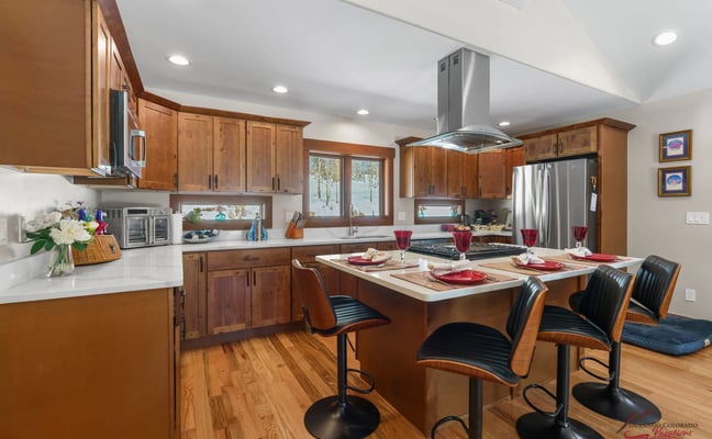 Tall Pines Casita kitchen with island, bar seating, and red place settings
