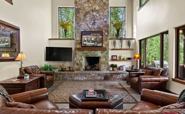 Engineer House 487 living room with floor-to-ceiling stone fireplace and aspen views