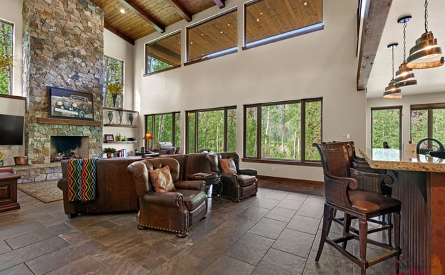 Engineer House 487 great room with stone fireplace, leather seating, and bar